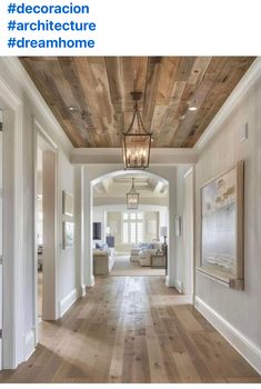 an open floor plan with wood floors and white walls, in the middle of a hallway