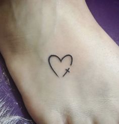 a heart with a cross tattoo on the foot