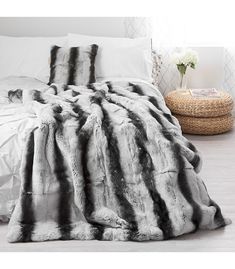 a black and white fur blanket on top of a bed