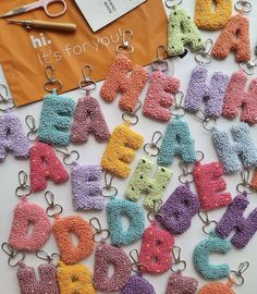 crocheted letters are displayed on a table with scissors and other crafting supplies