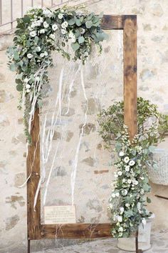 an old wooden frame decorated with flowers and greenery for a wedding ceremony in italy