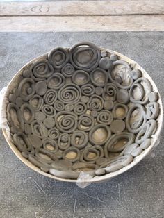 a bowl that is made out of clay and has circles in the center on it