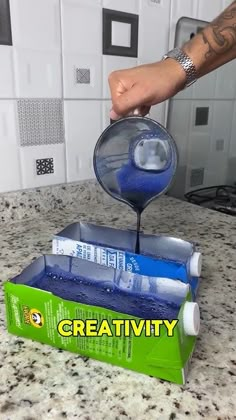 a hand is pouring blue liquid into a container