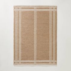 a beige and white rug hanging on the wall