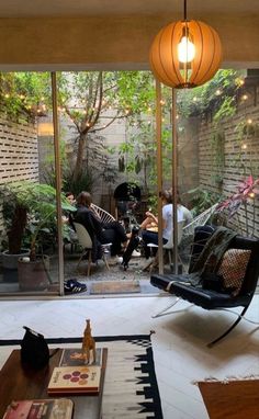 a living room filled with furniture and lots of plants on the wall next to it