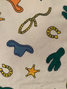 a close up of a white fabric with various items on it, including hats and stars