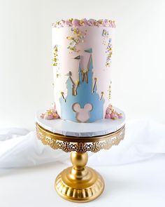 a pink and blue cake sitting on top of a gold plate