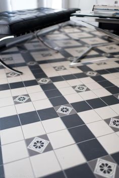 a black and white checkered tile floor in a living room with a glass coffee table