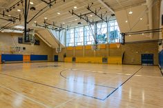 an indoor basketball court with hard wood flooring and blue trims is pictured in this image