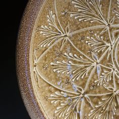 a brown and white bowl with designs on the bottom is seen in this close up photo