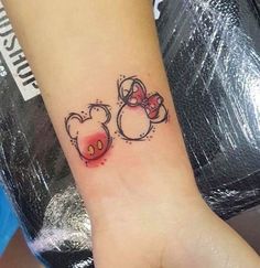 a small wrist tattoo with two minnie mouses on it