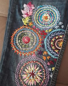 a pair of jeans with embroidered flowers on them