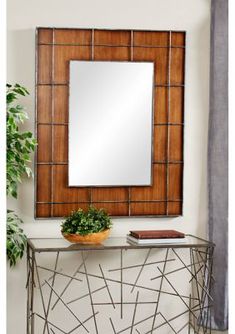 a mirror sitting on top of a table next to a potted plant