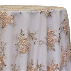 the table cloth has gold flowers on it and is white with gold trimmings