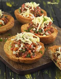 some food that is on top of a wooden table and has been placed in muffins