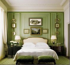 a bedroom with green walls and white bedding