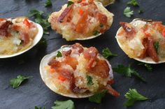 small appetizers with bacon, cheese and parsley on a black table top