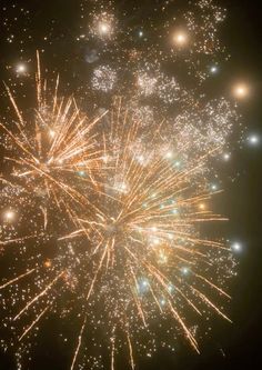 fireworks exploding in the night sky with lots of lights on it's sides and small stars above them