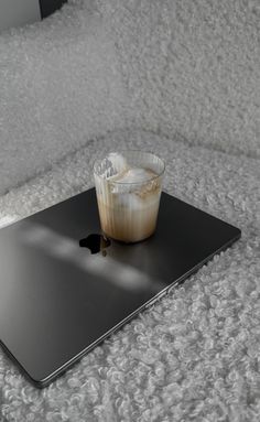 an apple macbook air laptop with ice cream on it sitting on a fluffy white blanket