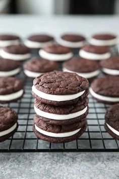 chocolate cookies with white frosting stacked on a cooling rack