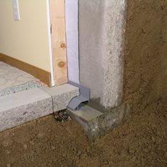 the corner of a room that is under construction with concrete blocks and cement bricks on the ground