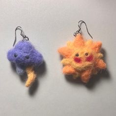 two needle - felt sun and moon ornaments hanging from hooks