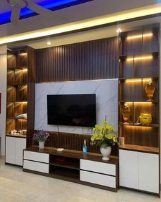 a living room filled with furniture and a flat screen tv on top of a wooden entertainment center