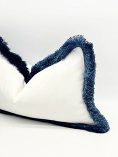 a blue and white decorative pillow on a white background