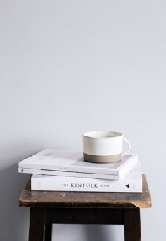 a stack of books with a cup on top