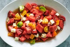 a white bowl filled with watermelon and feta cheese