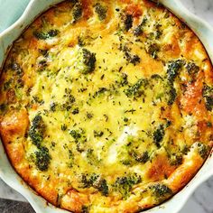 broccoli and cheese casserole in a white dish on a marble surface