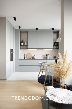 an open kitchen and dining area with white cabinets, wood flooring and blue rug