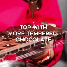 a person pouring chocolate into a tray with the words top with more tempered chocolate