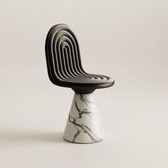 a black and white chair sitting on top of a marble base