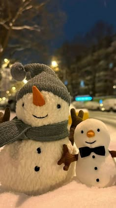 two snowmen are standing in the snow