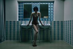 a woman standing in front of a bathroom sink