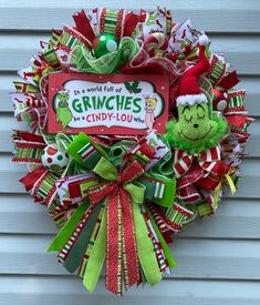 a christmas wreath hanging on the side of a house with grinnies candy - louy - louy