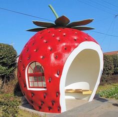 a large strawberry shaped building with a window