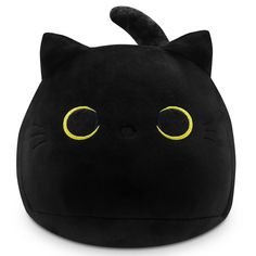 a black cat pillow with yellow eyes