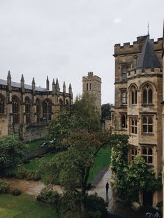 an aerial view of a building with trees in the foreground and people walking around