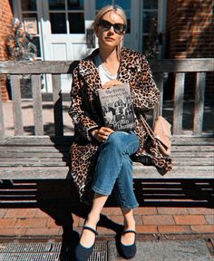 a woman sitting on top of a wooden bench