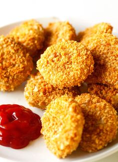 some fried food on a white plate with ketchup