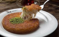 a piece of food on a white plate with a fork sticking out of the top