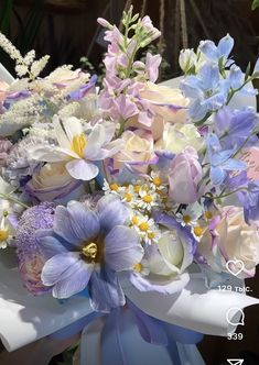 a bouquet of flowers sitting on top of a white table next to a blue ribbon