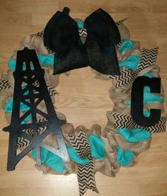 a wreath made out of burlock and ribbon with the letter c on it