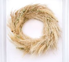 a dried wreath is displayed in a frame