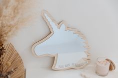 a mirror with a unicorn on it next to a fan and a glass of milk