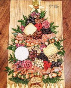 a christmas tree made out of cheeses, meats and other foods on a wooden table