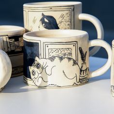 three coffee mugs sitting next to each other on top of a white countertop