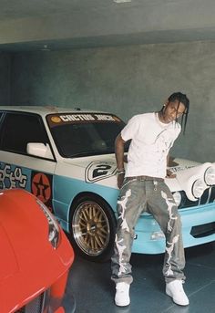 a man standing next to a car in a garage